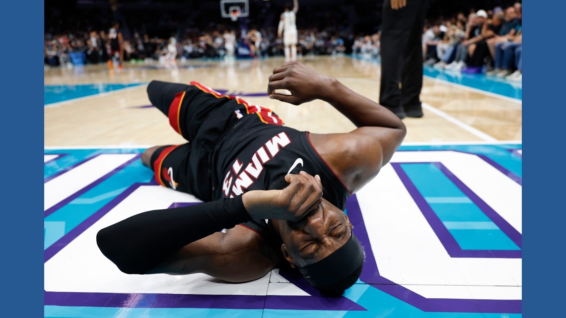 Heat's Bam Adebayo taken to locker room after LaMelo Ball trips him, leading to hard fall | king5.com