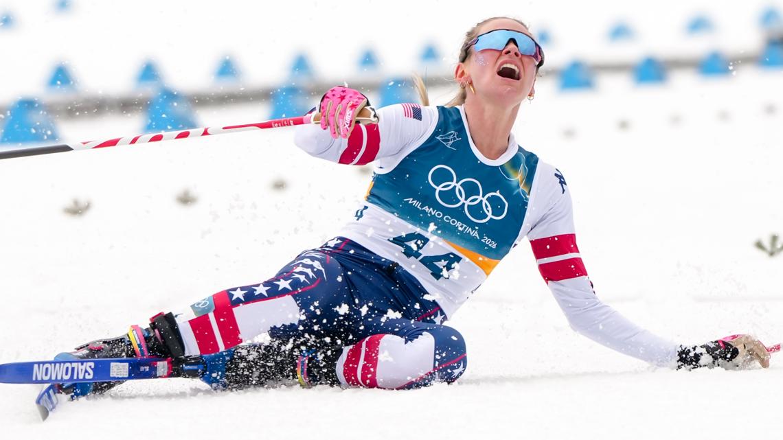 Jessie Diggins falls to the ground after crossing the finish line in the cross country skiing women's 10km interval start free at the 2026 Olympics.