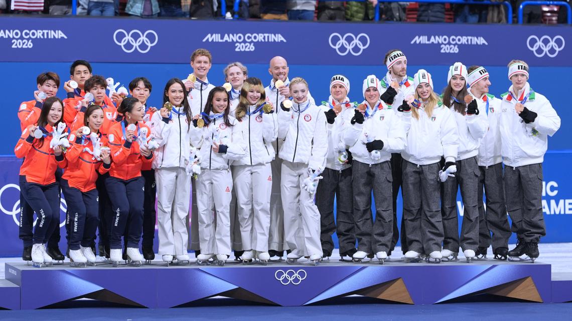 From left to right, silver medalists Team Japan, gold medalists Team USA and bronze medalists Team Italy receive their medals after figure skating