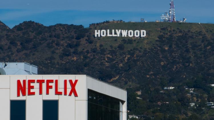 A Netflix sign is displayed atop a building in Los Angeles, on Dec. 18, 2025, with the Hollywood sign in the distance.