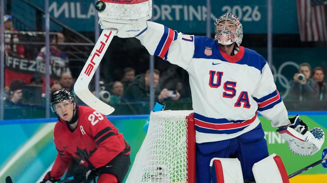 Connor Hellebuyck (37) knocks the puck out of the air in the men's hockey game between the U.S. and Canada at the Olympics, in Italy, Feb. 22, 2026.
