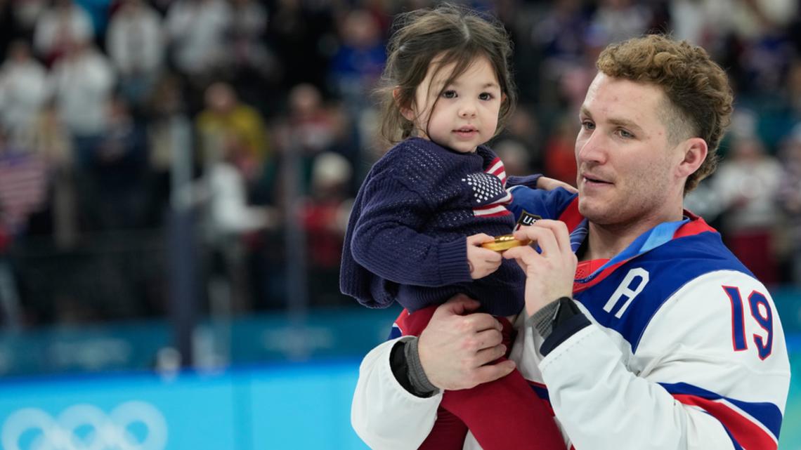 Matthew Tkachuk carries Noa Gaudreau after the men's hockey gold medal game between Canada and the U.S. at the 2026 Olympics in Italy, Feb. 22, 2026.