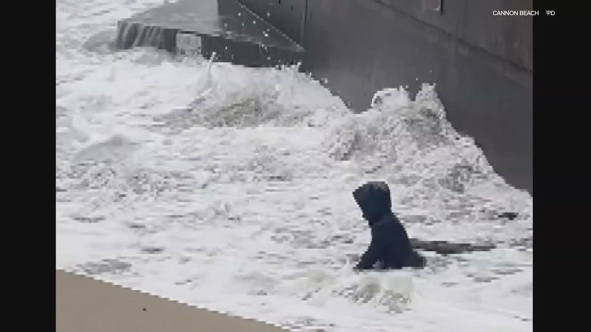 A video out of Cannon Beach, OR shows a woman struggling to maintain her balance during some powerful king tides on the beach