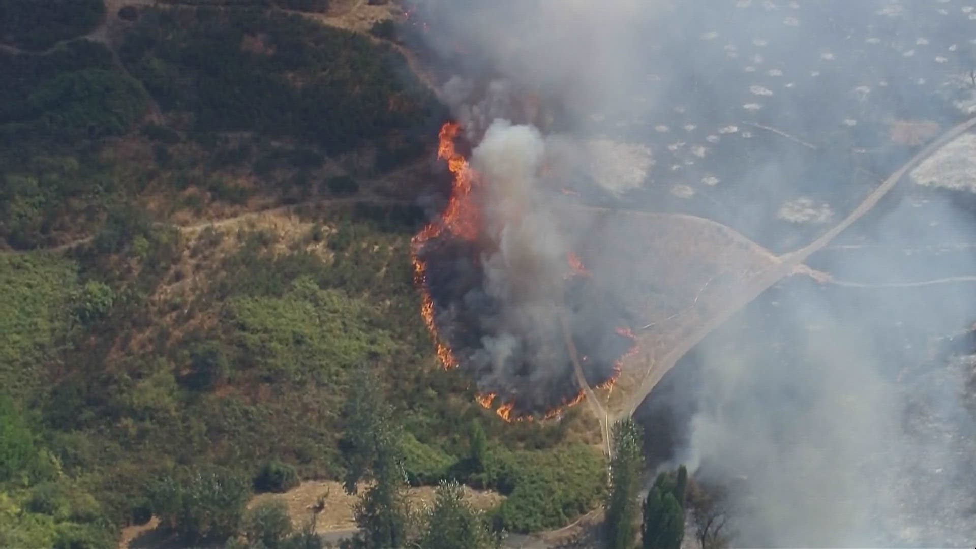 The fire came close to trees and homes, prompting officials to evacuate some residents.