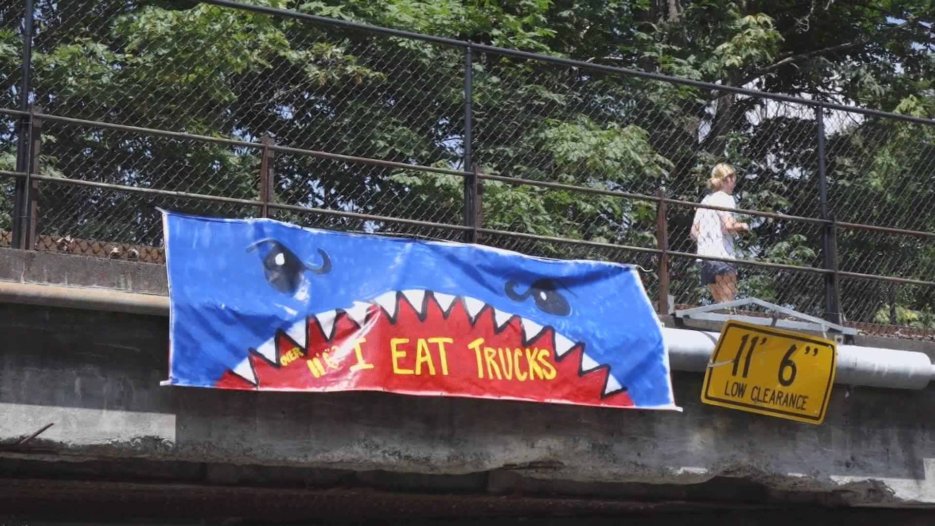 A Kirkland resident hung a banner on one side of the bridge with a picture of a shark saying "I eat trucks." The bridge is listed as "Truckbane" on Google Maps.