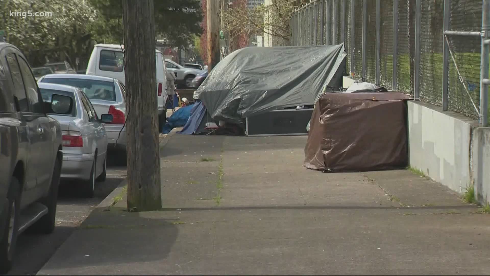 King County reports 27 people tested positive for coronavirus at homeless shelters. Advocacy groups say increased space and testing will help keep people safe.