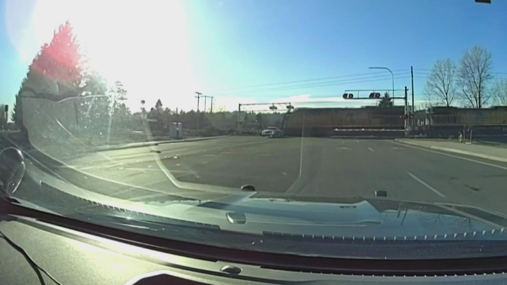 Officers responding a robbery call at the Coastal Farm and Ranch Store in Auburn caught this near miss on camera as the fleeing suspects barely escaped a train