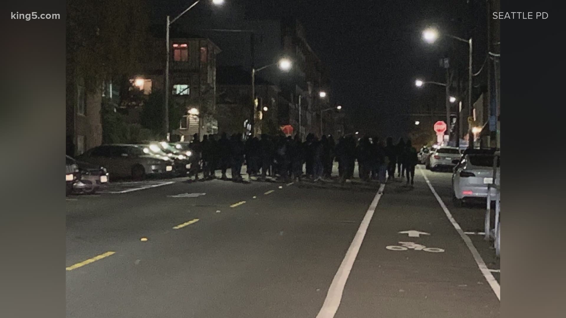 Dozens of people marched through the streets of Seattle's University District on Friday night breaking windows and graffitiing property, according to Seattle police.