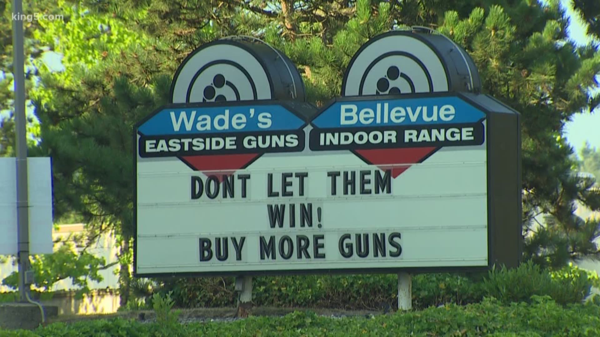 A gun shop owner is backing up his sign, saying it's in response to Washington's new gun laws, not the recent mass shootings.