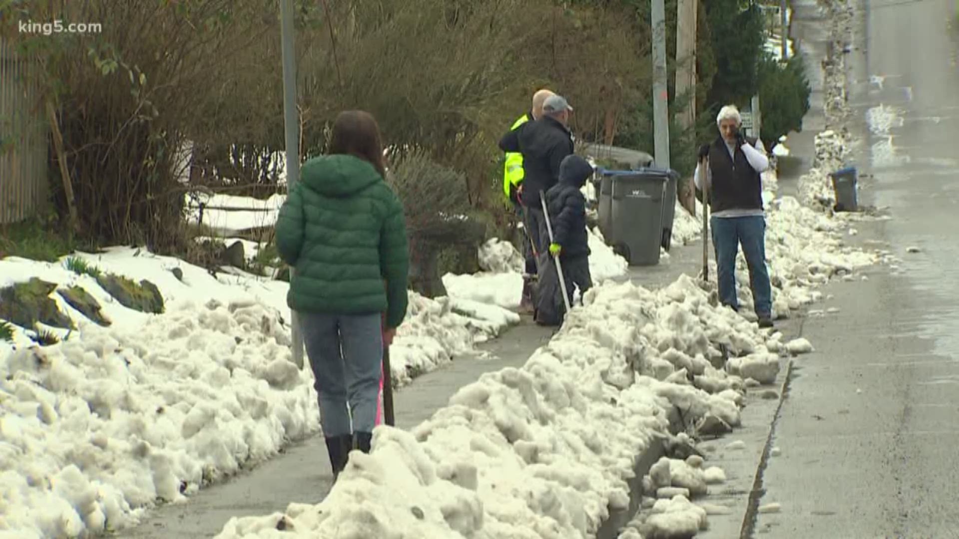 Volunteers cleared sidewalks so students could safely return to school on Tuesday