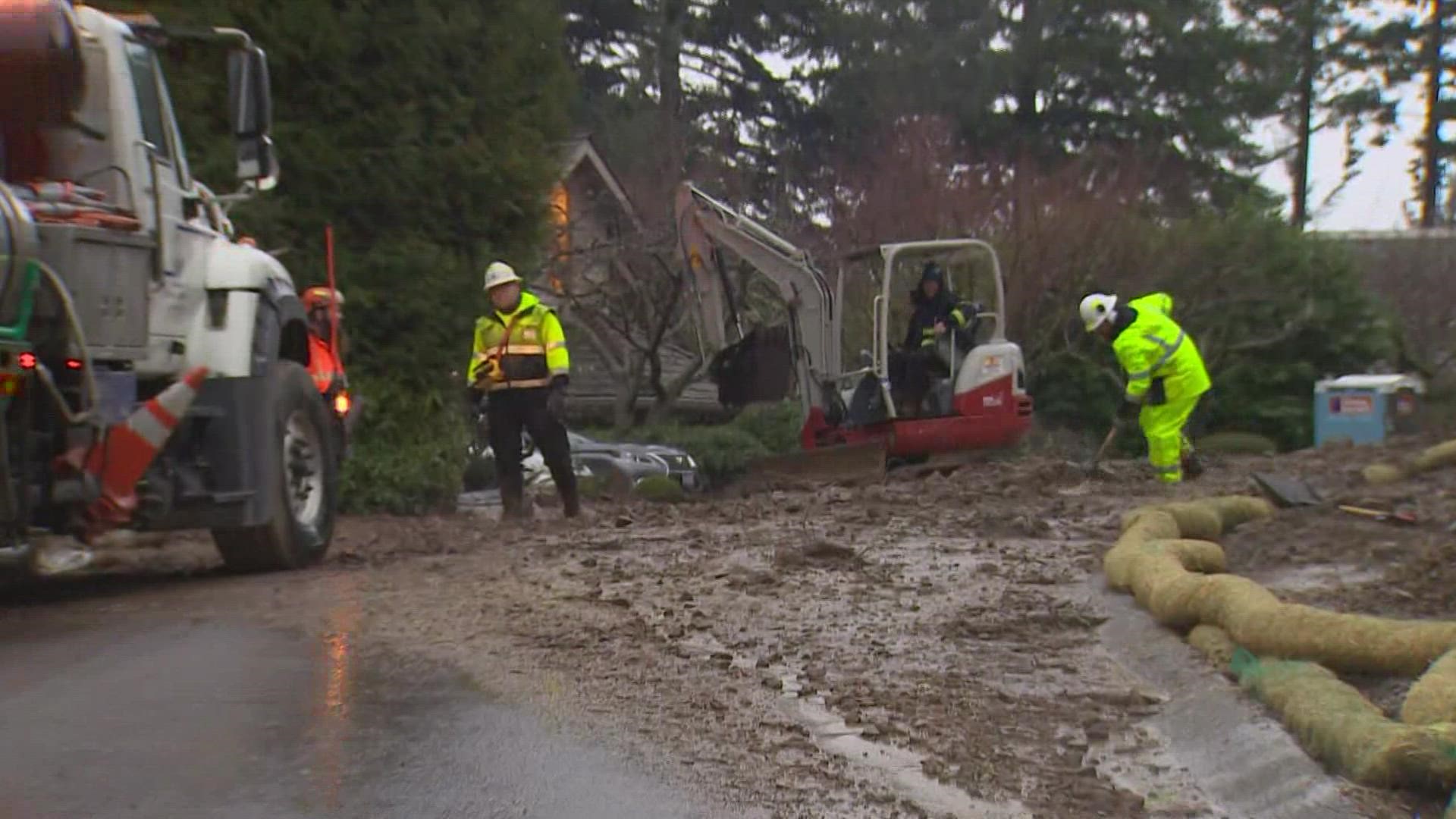 Crews were working Monday evening to remove mud and debris from a road through the neighborhood.