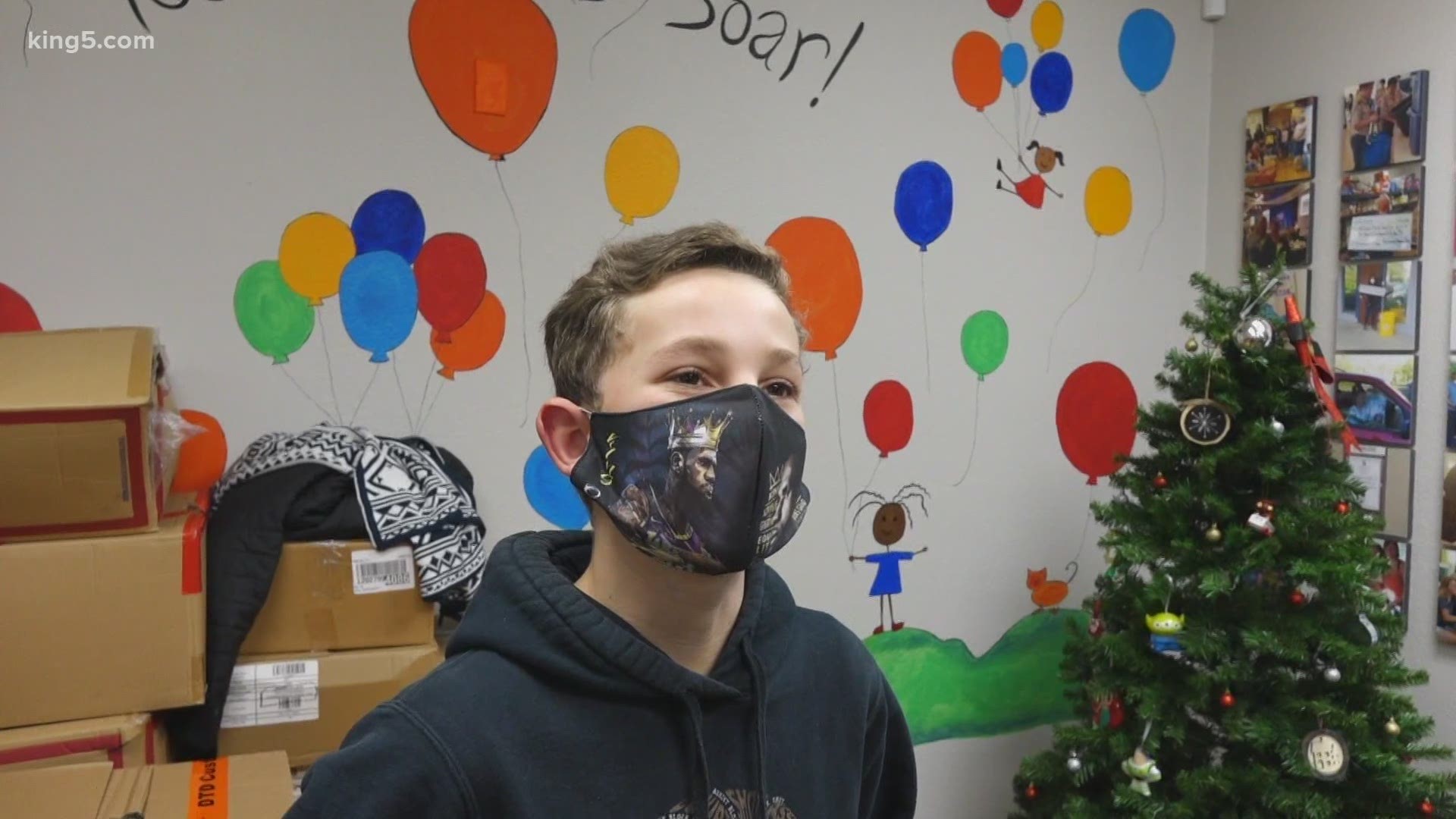 A teenage boy is helping a group of dedicated volunteers deliver a special Christmas for Kids in Transition in Washington state.