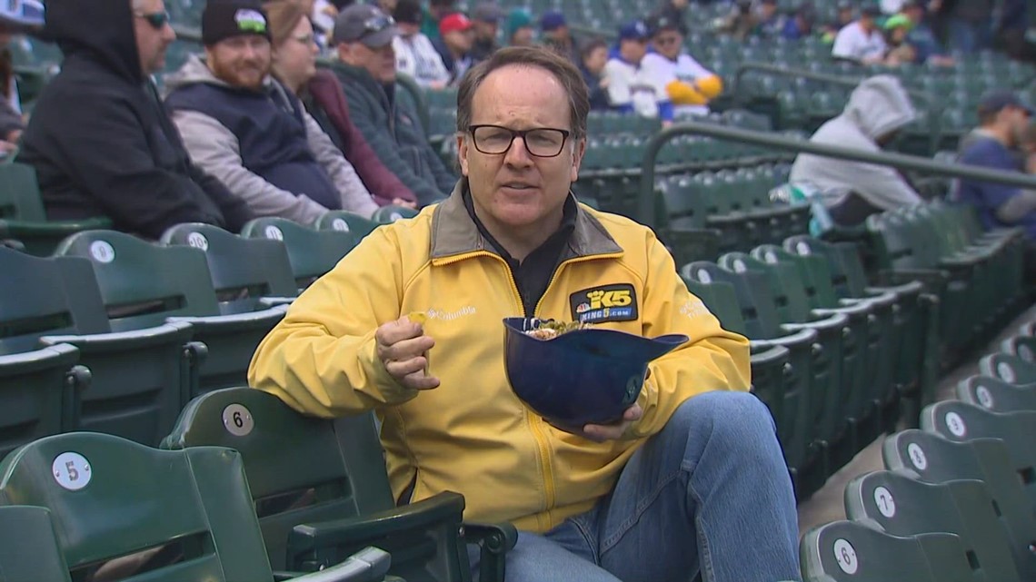 KING 5's Drew Mikkelsen enjoys a nacho helmet while reporting on Mariners opening day