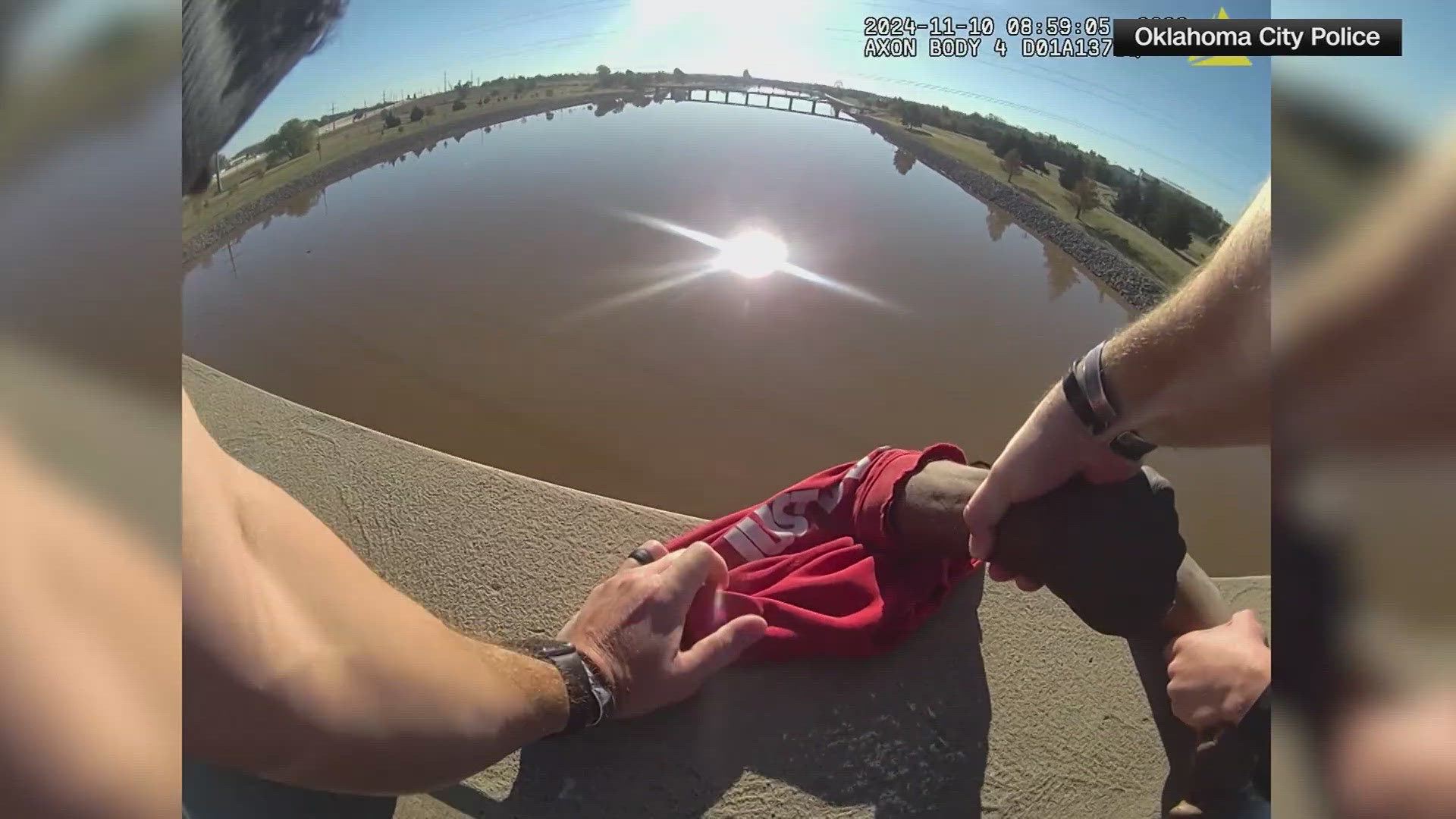 New video shows a police officer in Oklahoma City grab a man seconds before he rolled off of a guardrail and into a river