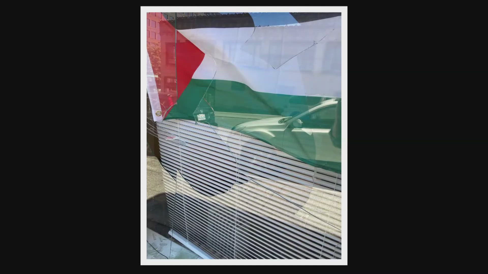 A Palestinian flag and a poster that reads "End U.S. military aid to Israel" were in the windows that had bricks thrown through them.