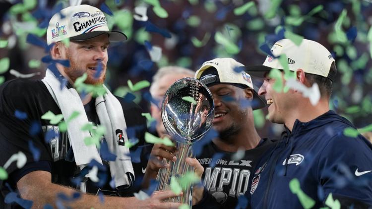 Seattle Seahawks head coach Mike Macdonald and quarterback Sam Darnold hold the Lombardi Trophy after their Super Bowl win on Feb. 8, 2026.