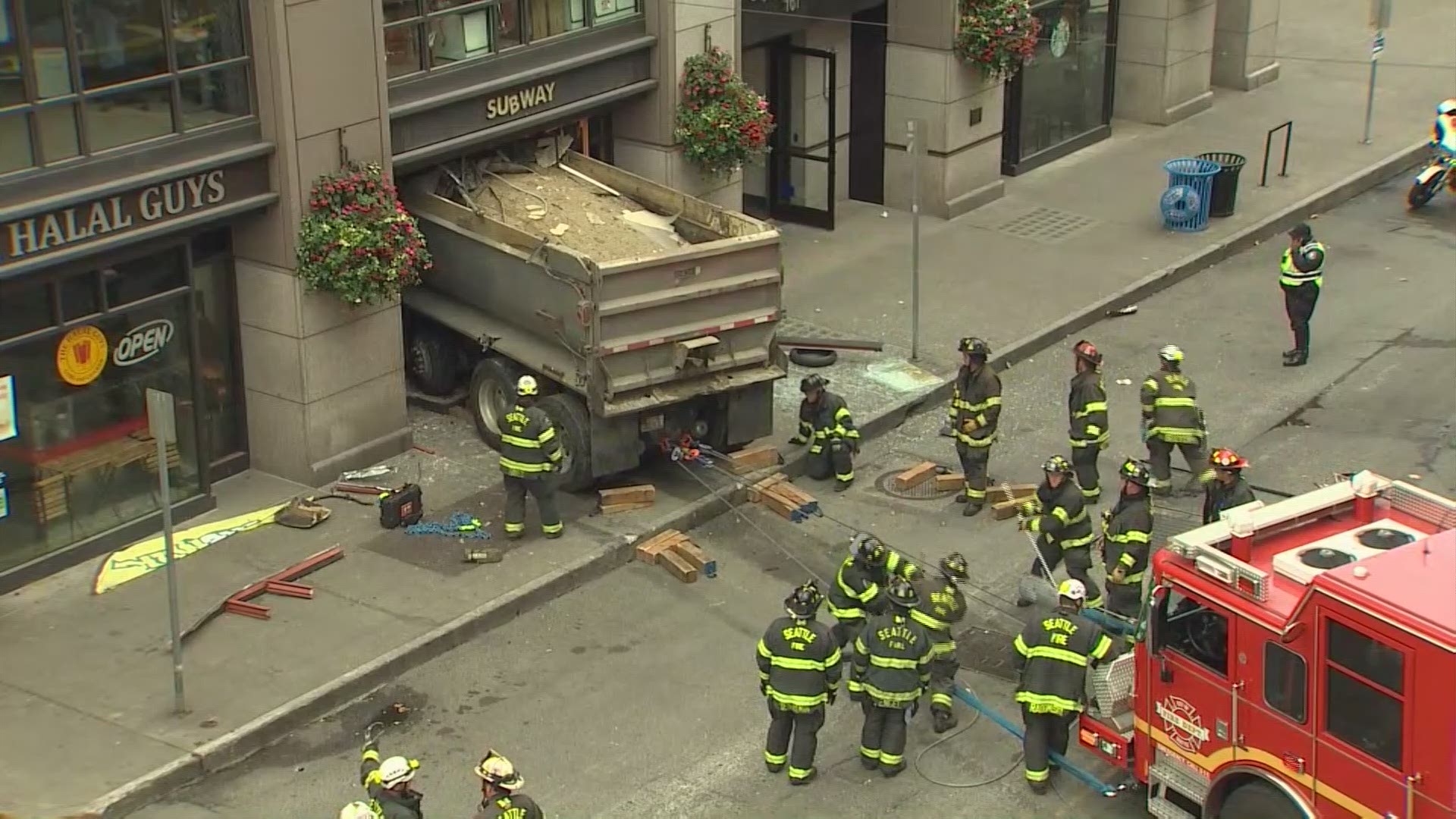 Firefighters worked to pull out a dump truck that crashed inside a Subway sandwich shop.