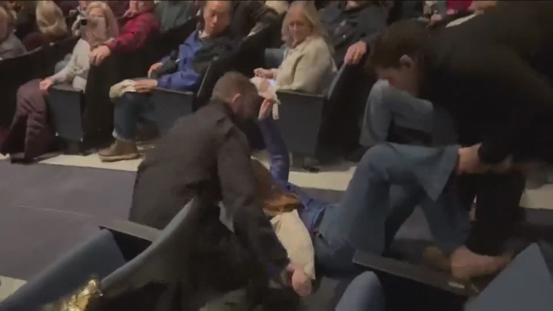 The city attorney for Coeur d'Alene confirmed charges have been filed against six men after a woman was forcefully removed from a town hall in February. 