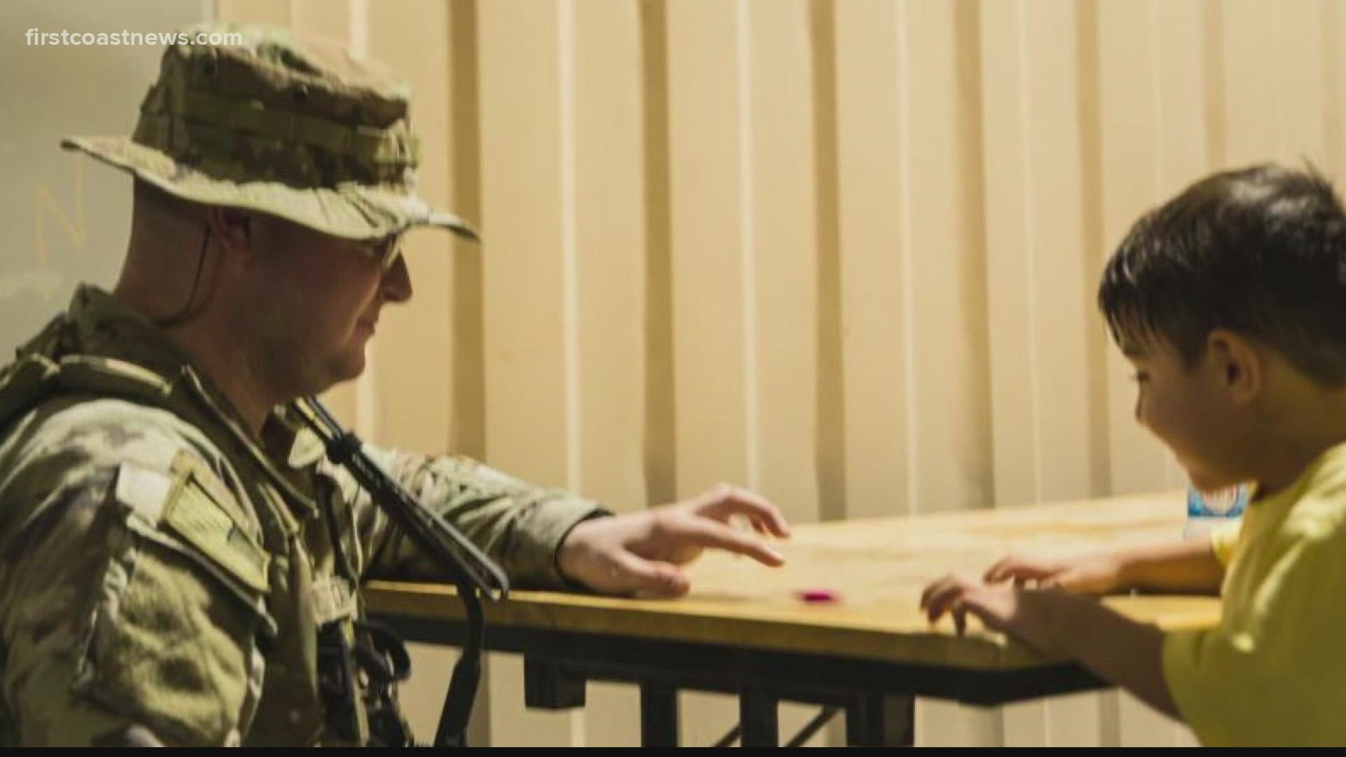 U.S. Army Specialist Joseph Tate, a native of Jacksonville, was playing with a child during a clothing distribution for Afghan evacuees in Qatar.